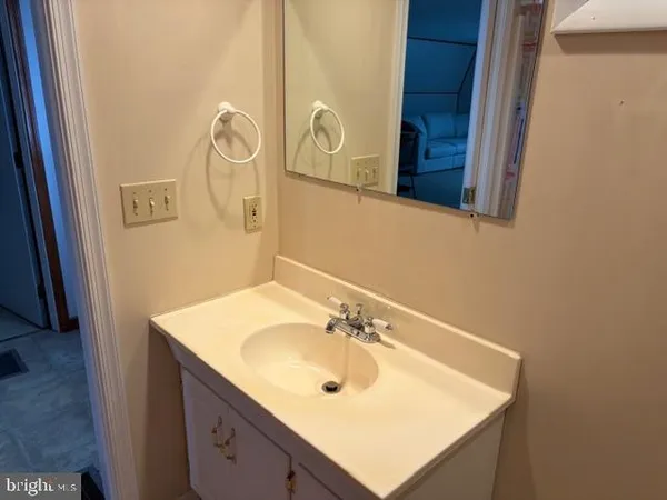 a bathroom with a sink vanity and a mirror