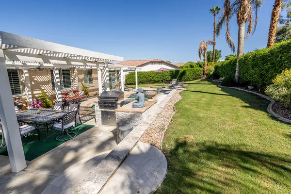 a view of a chairs and table in backyard