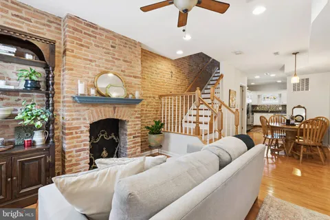a living room with furniture a fireplace and a chandelier