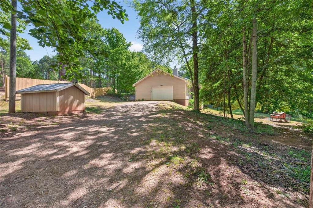 386 Ridgewood Drive Pendergrass, GA 30567 - Photo 44 of 50 a backyard of a house with a garden and tree