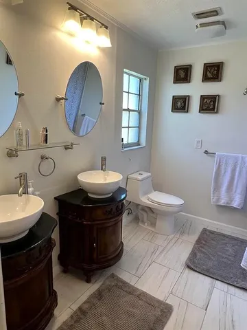 a bathroom with a toilet sink and mirror