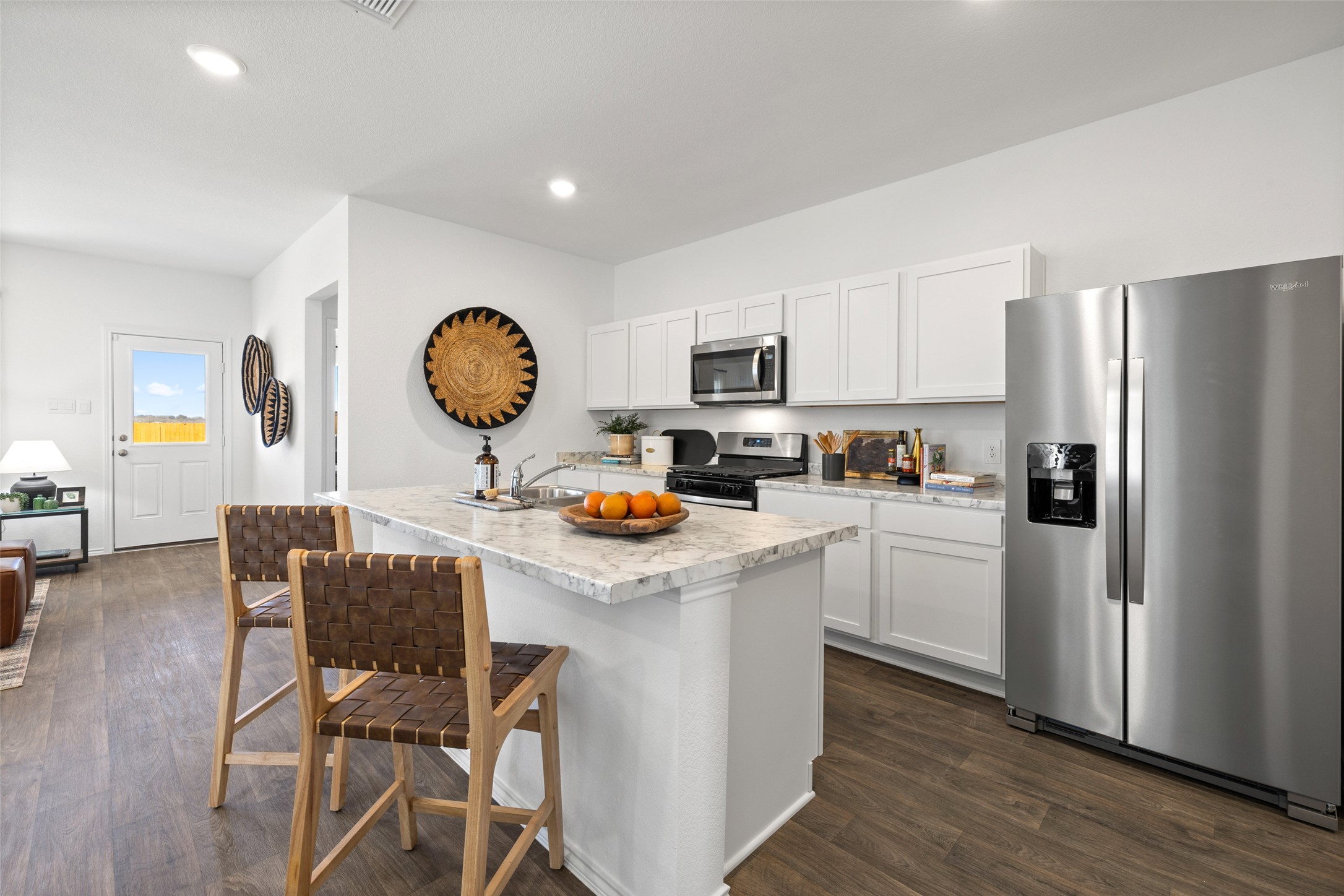879 Arnold Loop Kyle, TX 78640 - Photo 16 of 33 a kitchen with a sink a refrigerator and a stove top oven
