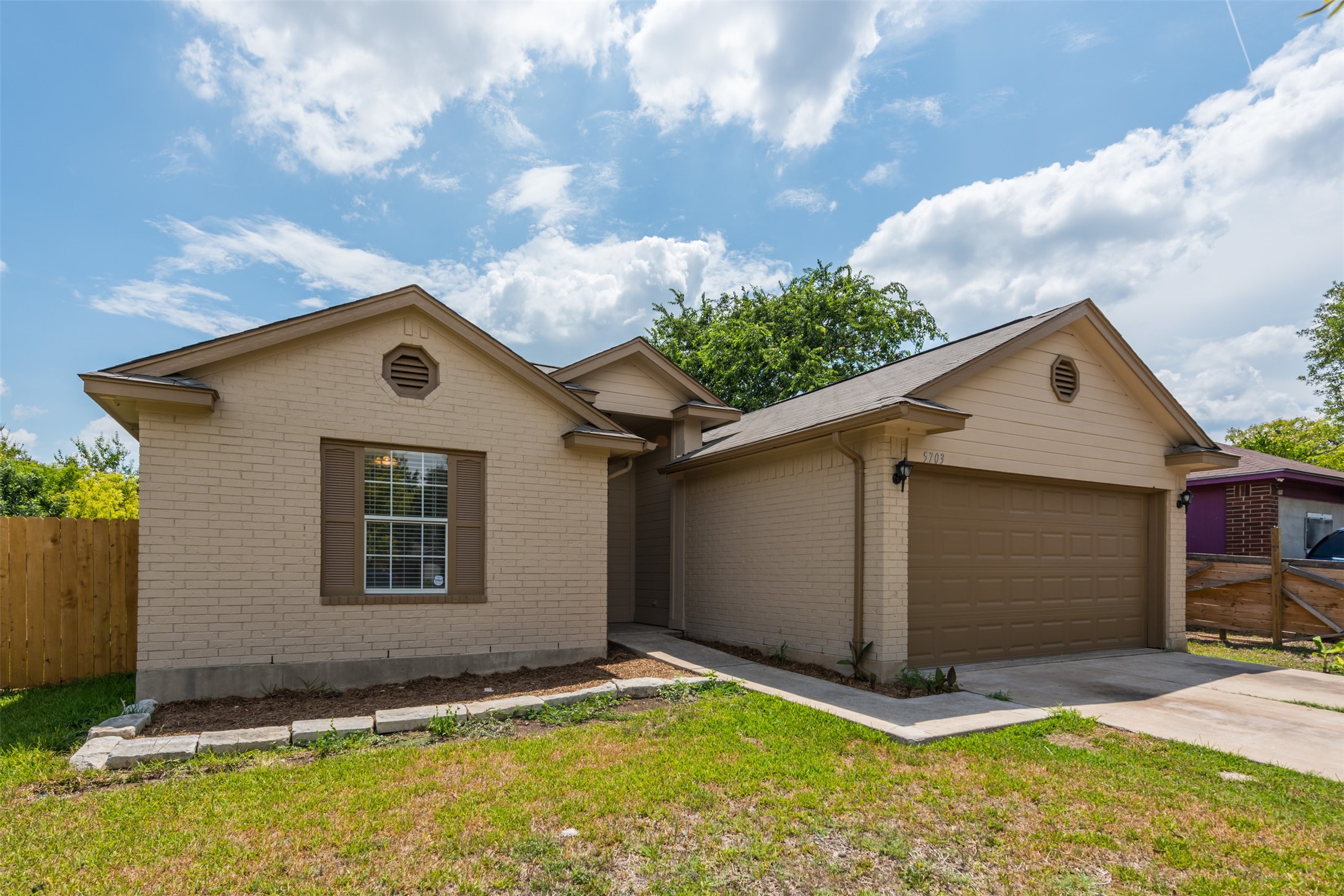 5703 Teri Road Austin, TX 78744 - Photo 2 of 16 a backyard of a house with yard and garage