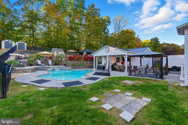a front view of a house with swimming pool having outdoor seating