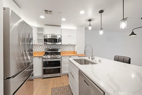 a kitchen with kitchen island a sink stainless steel appliances and cabinets