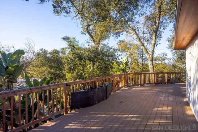 a living room with a couch a dining table and chairs with wooden floor