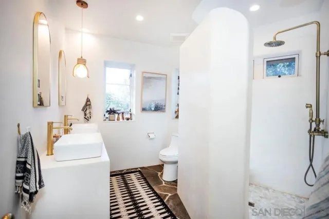 a bathroom with a sink a toilet and mirror