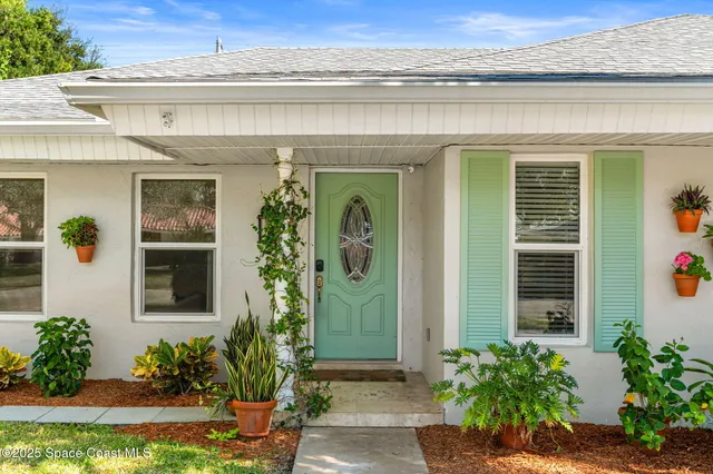 a front view of a house with potted plants