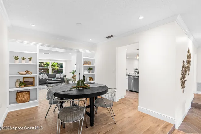 a living room with furniture and a large window with kitchen view