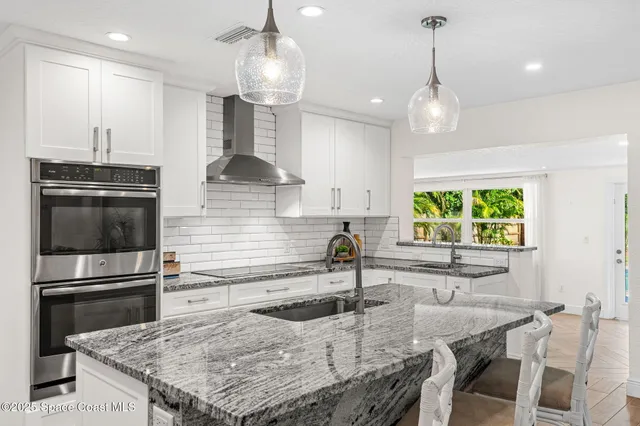 a kitchen with stainless steel appliances kitchen island granite countertop a sink and cabinets