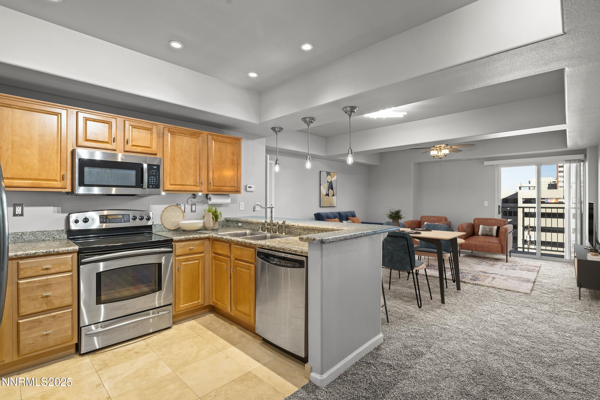 200 West 2nd Street, Unit 502 Reno, NV 89501 - Photo 4 of 35 a open kitchen with stainless steel appliances granite countertop a stove top oven a sink dishwasher a dining table and chairs with wooden floor