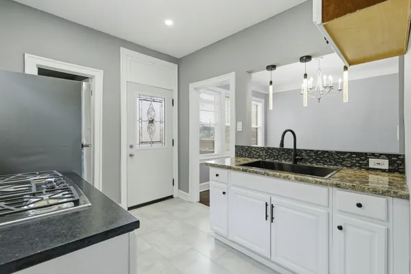 a kitchen with granite countertop a stove and a sink