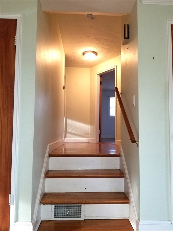 225 Governors Road, Unit 225 Quincy, MA 02169 - Photo 9 of 19 a view of staircase with lots of frames on wall