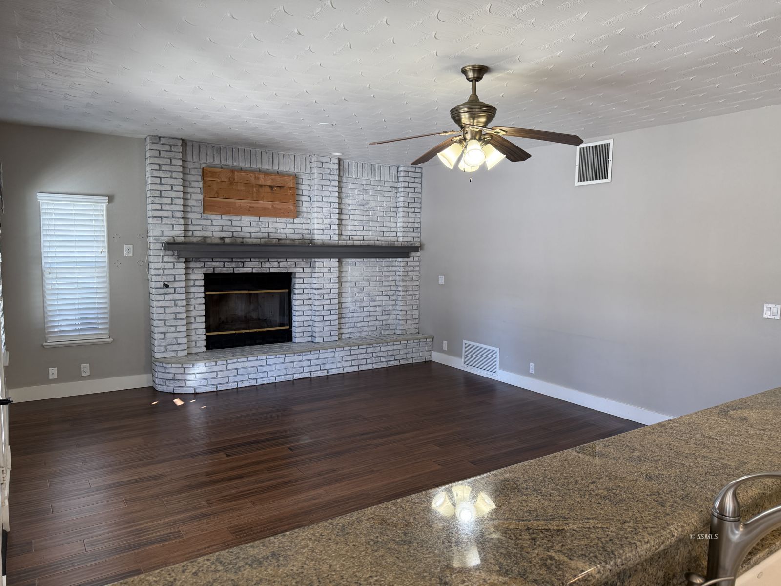 413 Laurkris Court Ridgecrest, CA 93555 - Photo 8 of 48 an empty room with wooden floor fireplace and a window