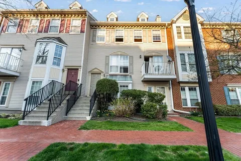 a front view of a building with a garden and plants