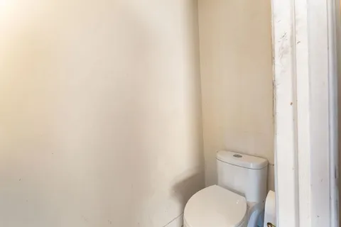 a white toilet sitting next to a white wall