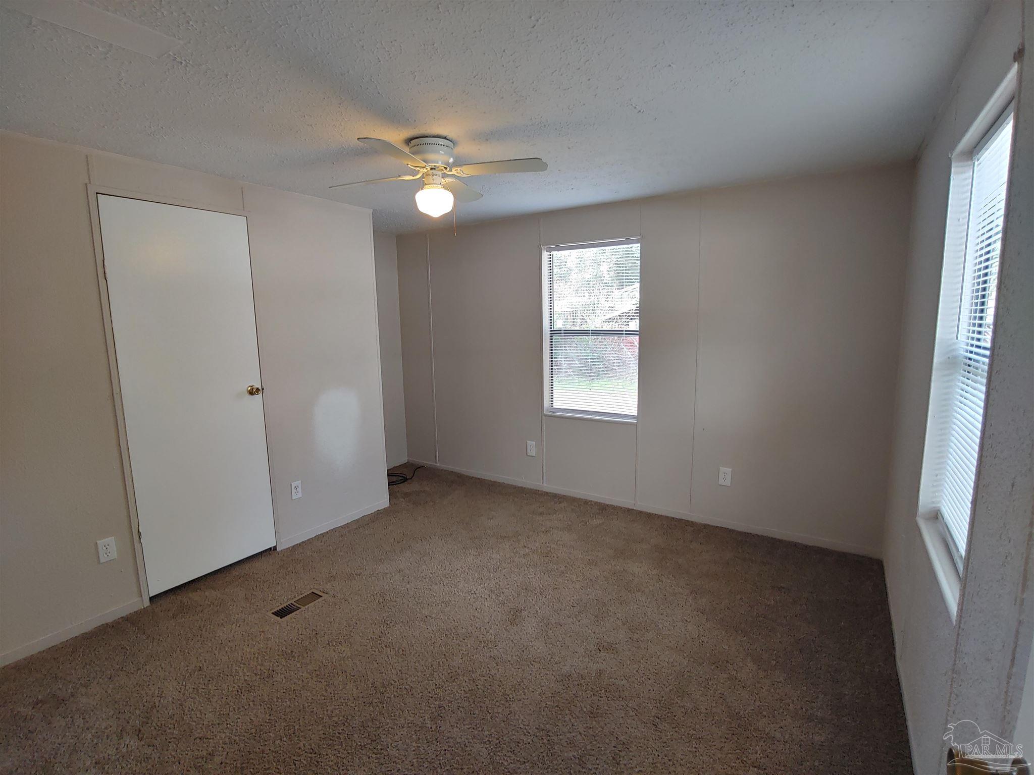 2821 Hillcrest Avenue, Unit 10 Pensacola, FL 32526 - Photo 7 of 14 an empty room with windows and closet area