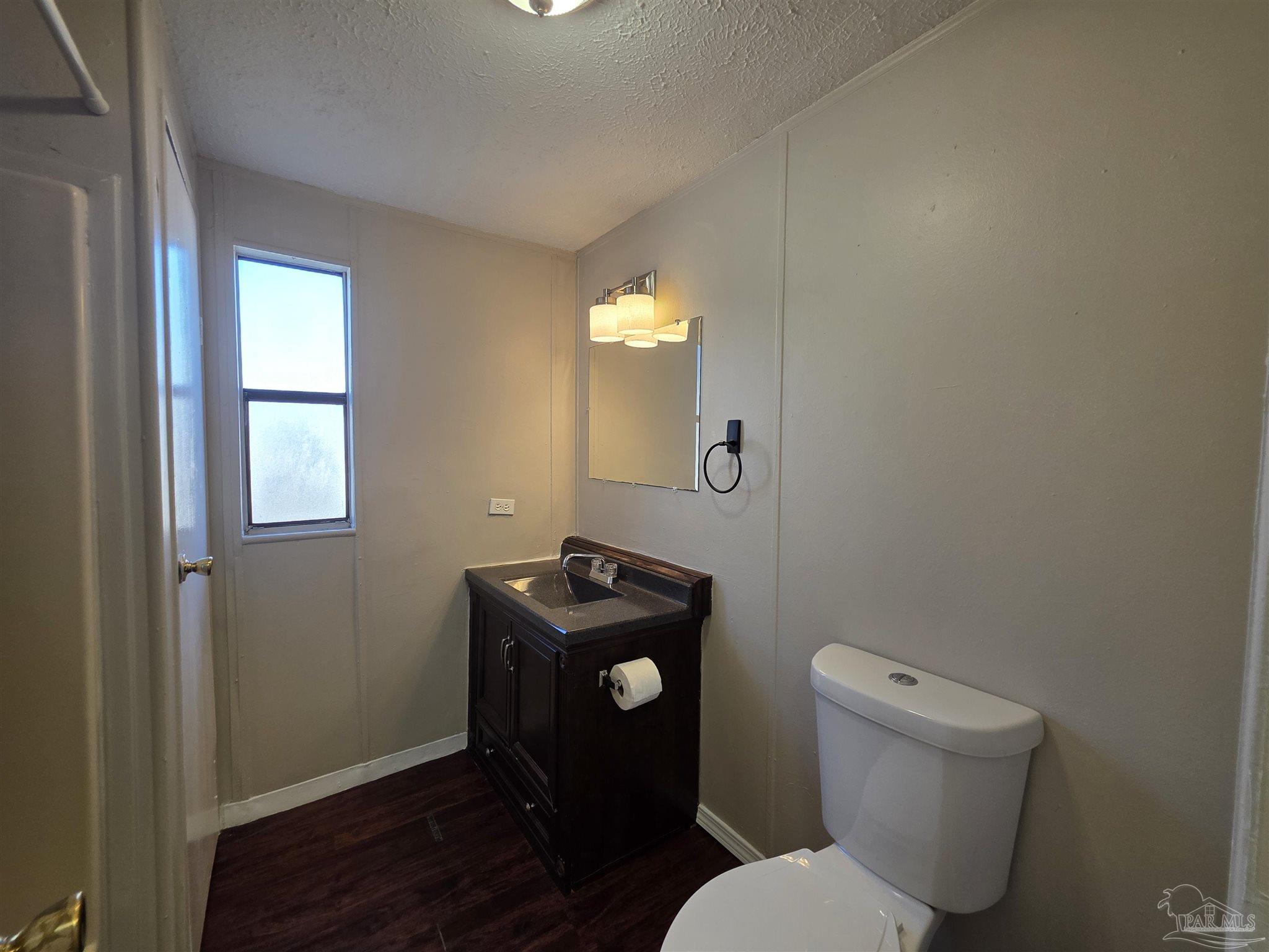 2821 Hillcrest Avenue, Unit 10 Pensacola, FL 32526 - Photo 9 of 14 a bathroom with a toilet sink vanity and mirror