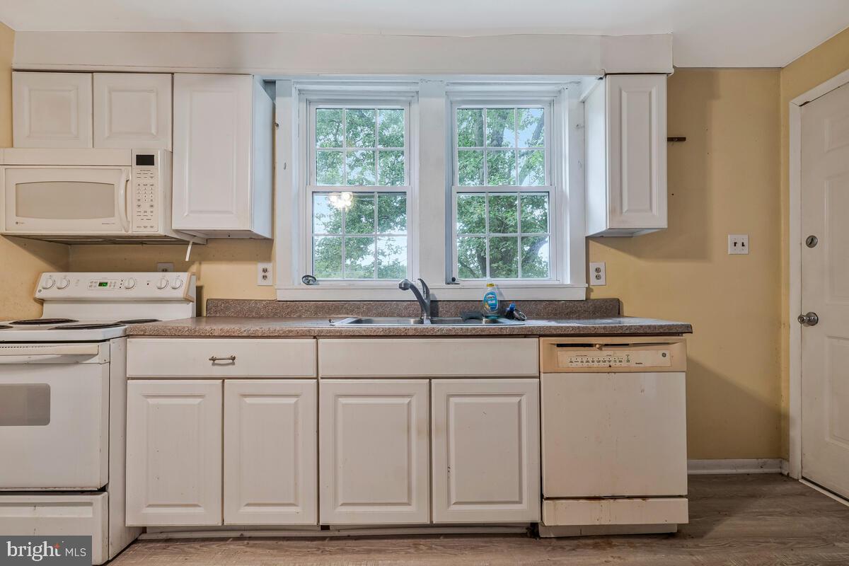 38888 Reeves Road Mechanicsville, MD 20659 - Photo 27 of 50 a kitchen with granite countertop white cabinets and white appliances