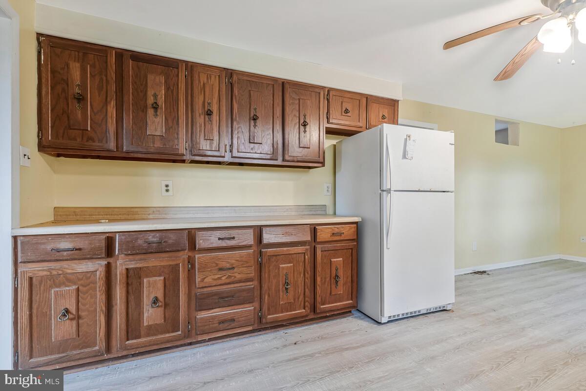 38888 Reeves Road Mechanicsville, MD 20659 - Photo 29 of 50 a kitchen with wooden cabinets and refrigerator