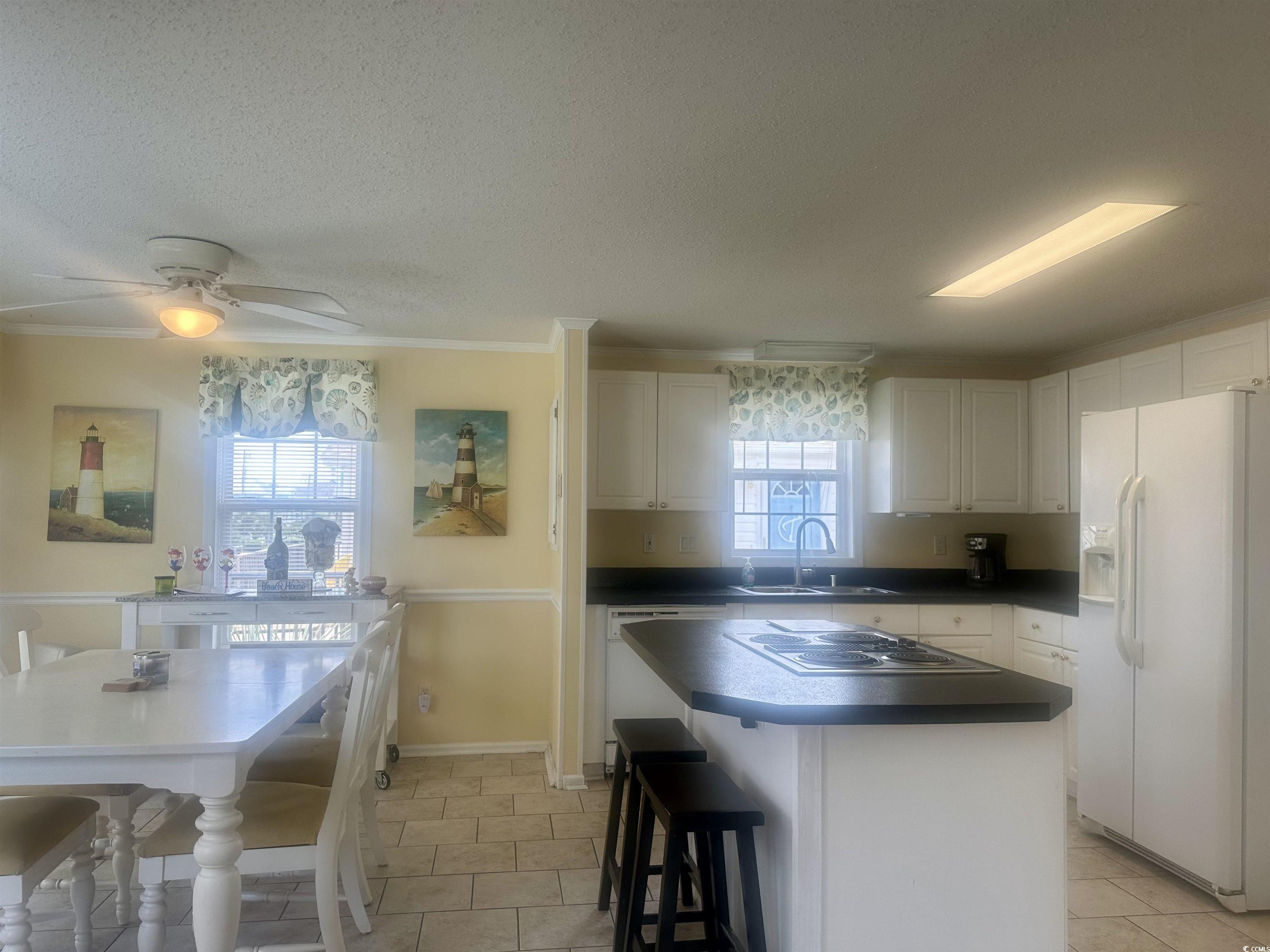 1752 Mason Circle Murrells Inlet, SC 29576 - Photo 24 of 31 Kitchen with light tile patterned flooring, white cabinets, sink, white refrigerator with ice dispenser, and a center island