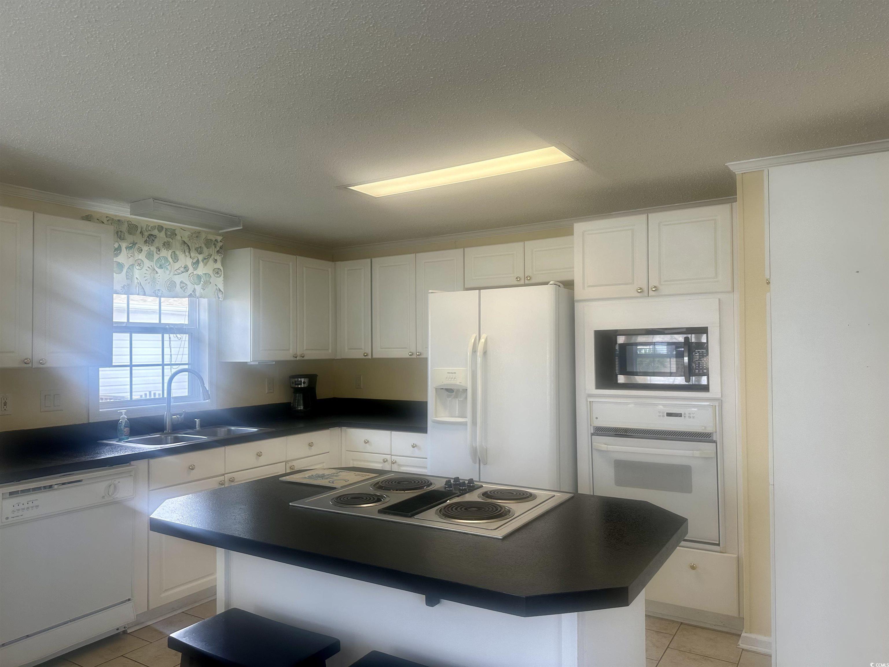 1752 Mason Circle Murrells Inlet, SC 29576 - Photo 5 of 31 Kitchen with light tile patterned flooring, white cabinetry, a center island, stainless steel appliances, and sink