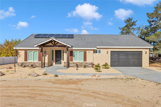 a view of an empty room with wooden floor and a ceiling fan
