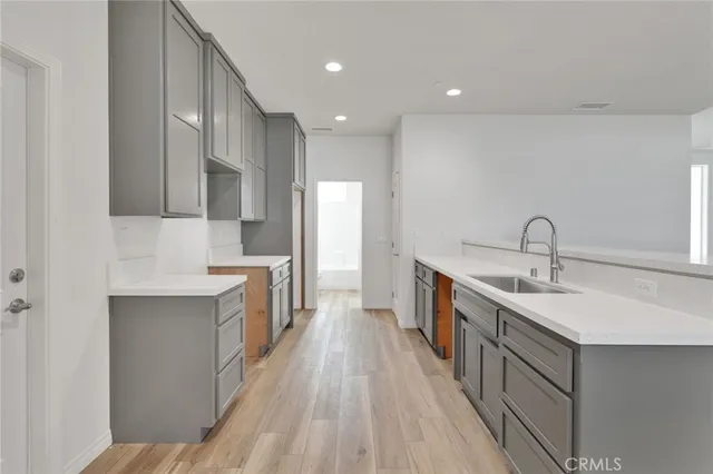 a kitchen with a refrigerator sink and cabinets