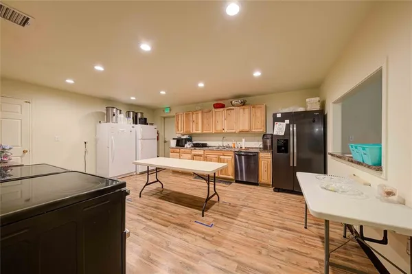 a kitchen with stainless steel appliances wooden floor and a stove top oven