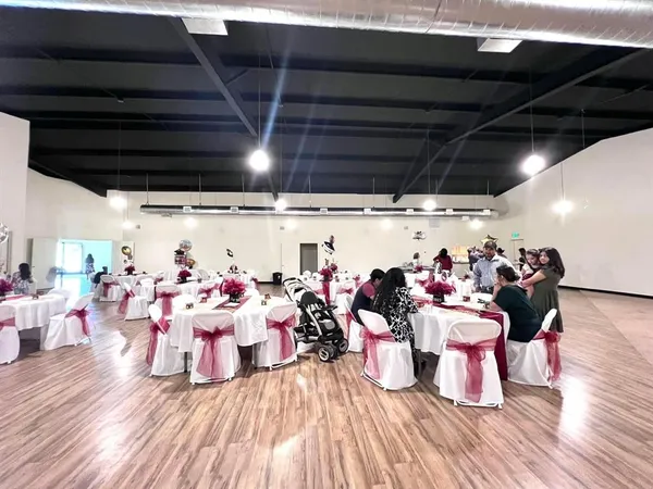 a group of people sitting in a room with wooden floor