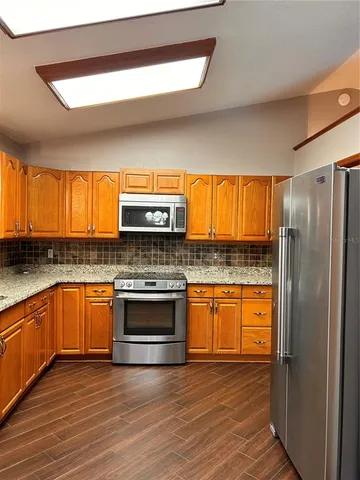 a kitchen with stainless steel appliances granite countertop a stove and a refrigerator
