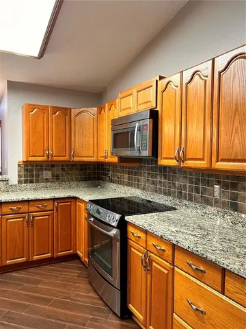 a kitchen with granite countertop a sink and a stove top oven