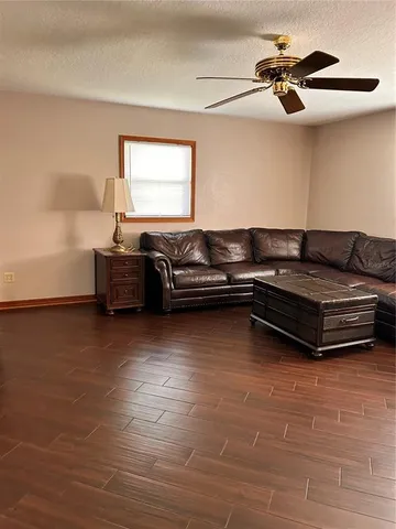 a living room with furniture and a ceiling fan