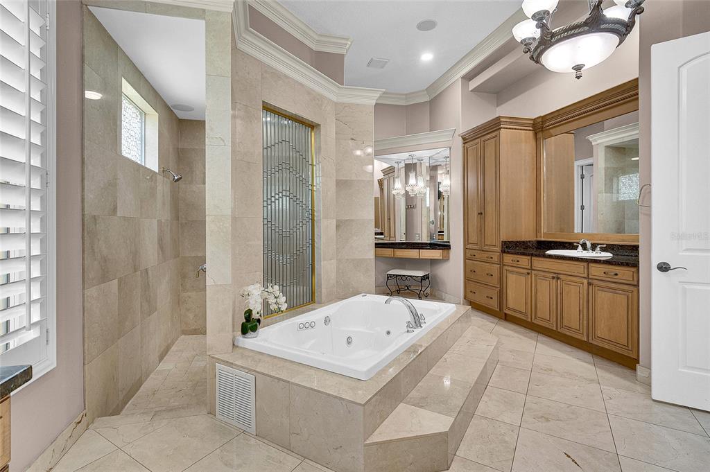 8707 Silverthorn Road Seminole, FL 33777 - Photo 19 of 58 a large white bathroom with a bathtub and a shower