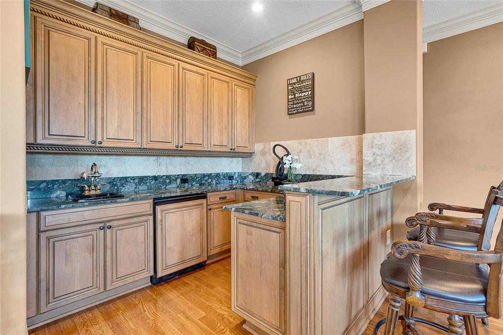 8707 Silverthorn Road Seminole, FL 33777 - Photo 23 of 58 a kitchen with granite countertop a sink stove and cabinets