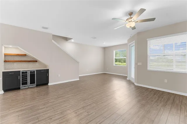 a view of a room with wooden floors and kitchen view