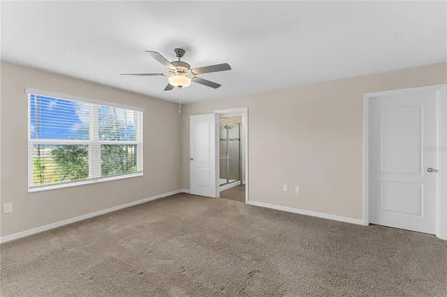 a view of an empty room with a ceiling fan