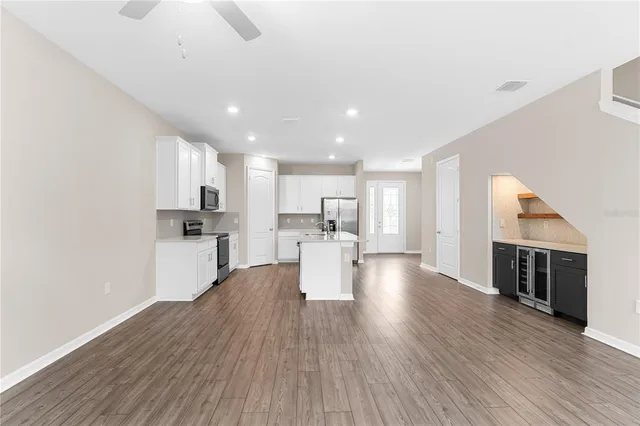 a view of kitchen with wooden floor and electronic appliances