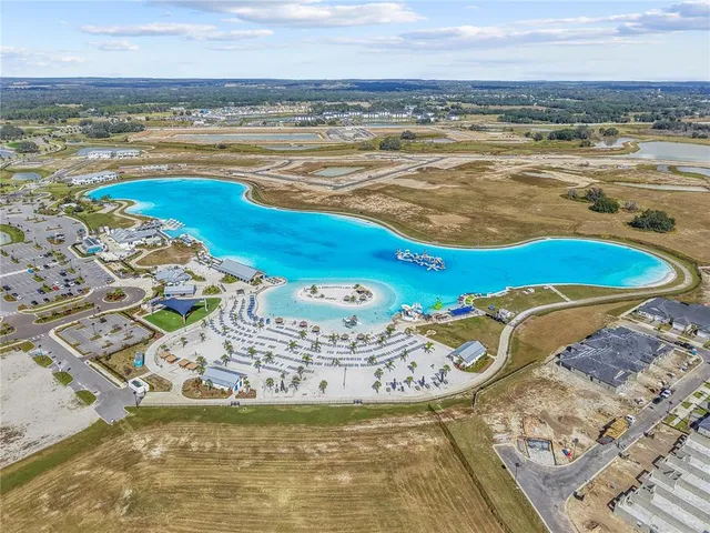 an aerial view of ocean and residential houses with outdoor space