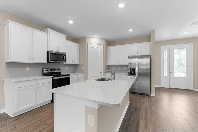 a kitchen with refrigerator cabinets and wooden floor