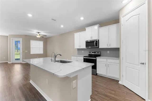 a kitchen with stainless steel appliances a refrigerator sink and microwave