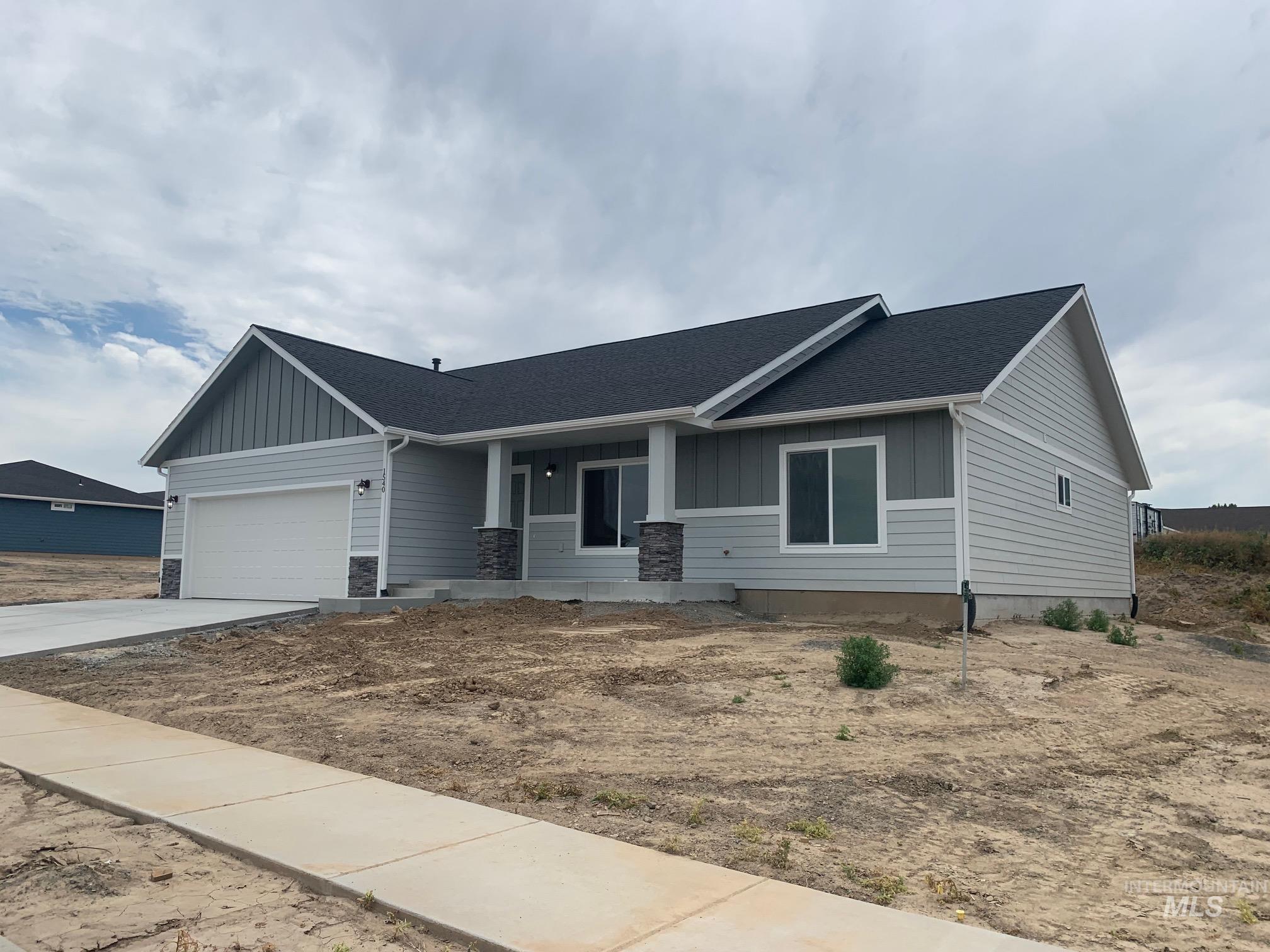 View of front of home with board and batten siding, covered porch, a shingled roof, a garage, and concrete driveway