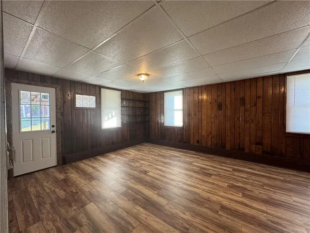 a view of an empty room with window and wooden floor