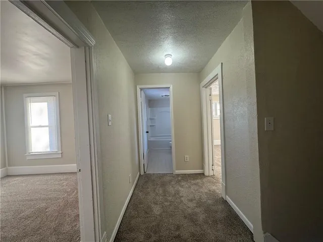 a view of hallway with windows and closet