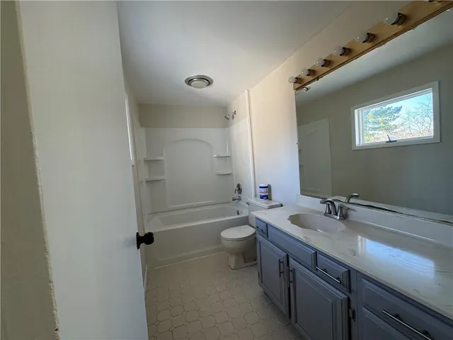 a bathroom with a double vanity sink toilet and a mirror