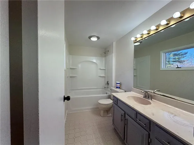 a bathroom with a double vanity sink toilet mirror and bathtub