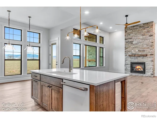 a kitchen with kitchen island a counter top space appliances and a living room view