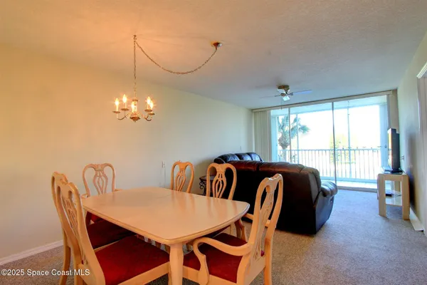 a view of a dining room with furniture a chandelier and wooden floor