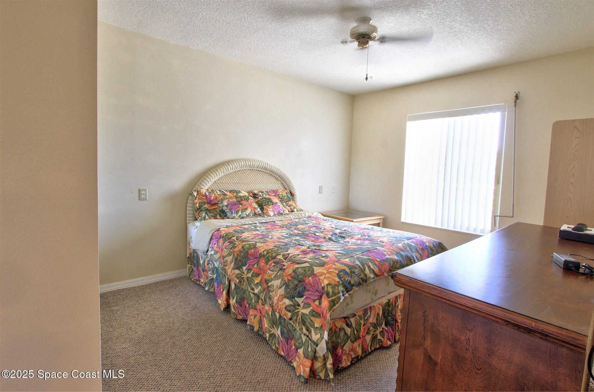 1420 Huntington Lane, Unit 2304 Rockledge, FL 32955 - Photo 24 of 34 a bedroom with a bed a dresser and potted plant
