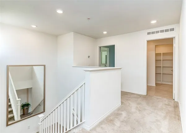 a view of a hallway to room with a window and a kitchen space